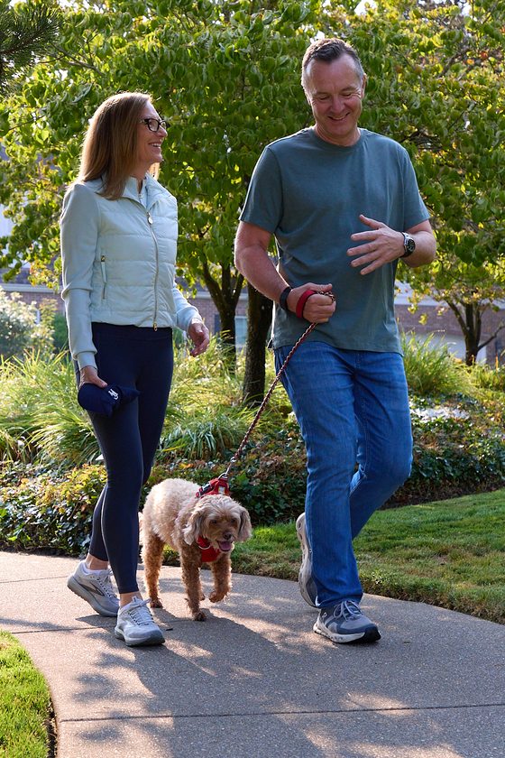 Neil and Claire Tunmore walking their dog along a Lake Oswego neighborhood path